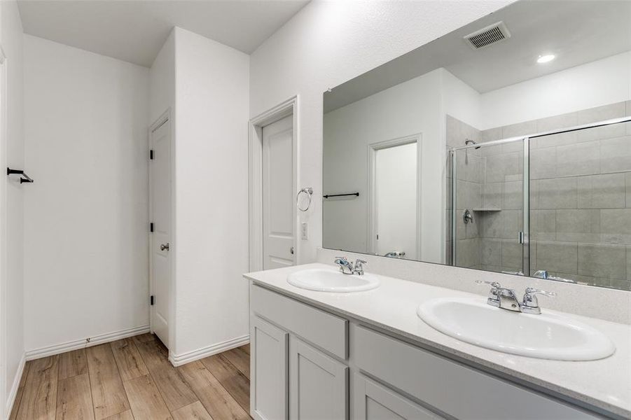 Bathroom featuring vanity, hardwood / wood-style flooring, and a shower with shower door