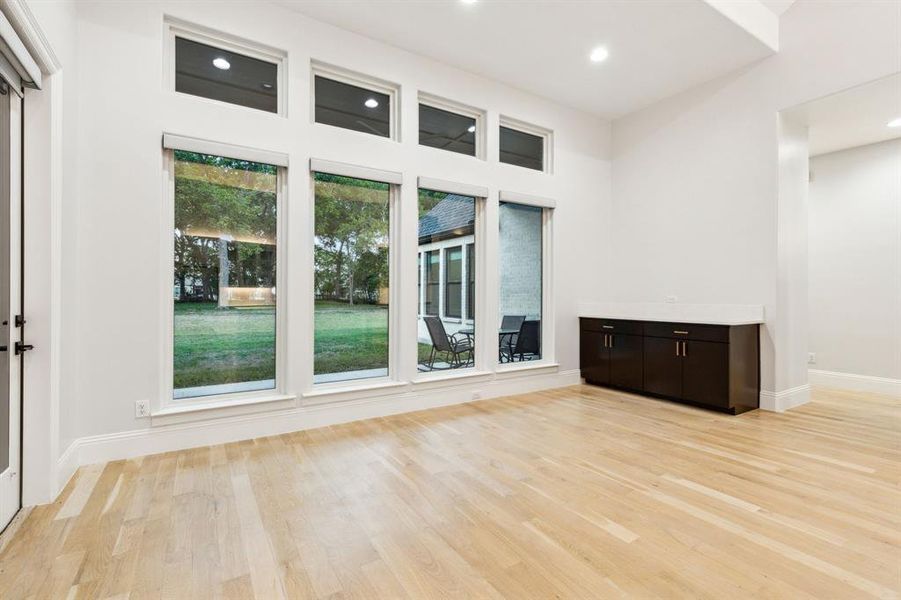 Large breakfast area with custom cabinets and wall of windows with electric Hunter Douglas blinds