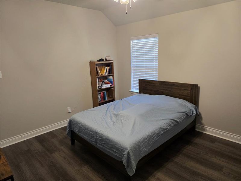 Bedroom with lofted ceiling and dark hardwood / wood-style floors