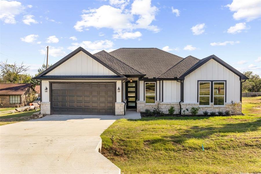 View of front of home with a garage and a front yard