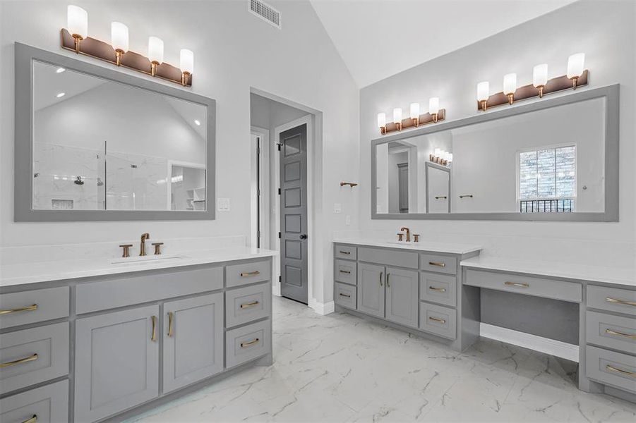 Bathroom with vaulted ceiling, tile flooring, and dual vanity