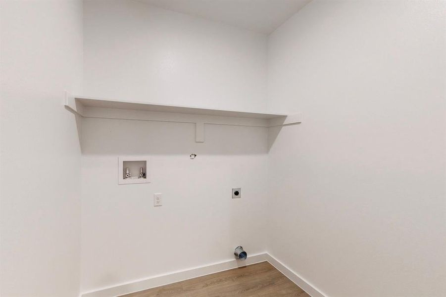 Laundry room with hookup for an electric dryer, washer hookup, hookup for a gas dryer, and hardwood / wood-style flooring