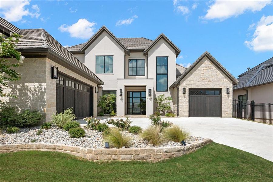 View of front of property featuring a garage and a front lawn