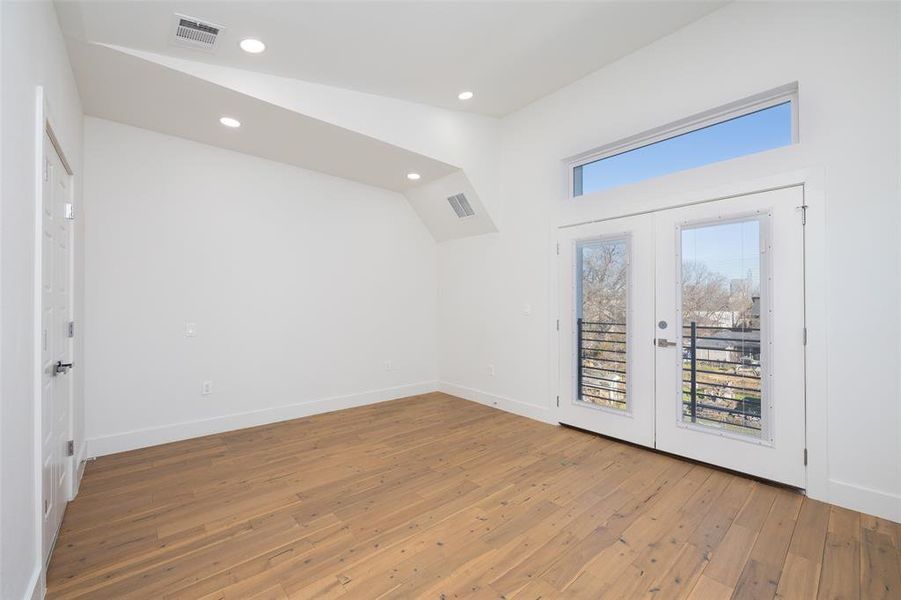 Unfurnished room featuring french doors, lofted ceiling, and wood-type flooring