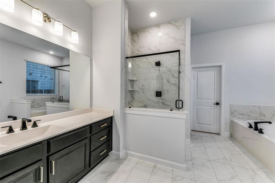 Bathroom featuring vanity and independent shower and bath