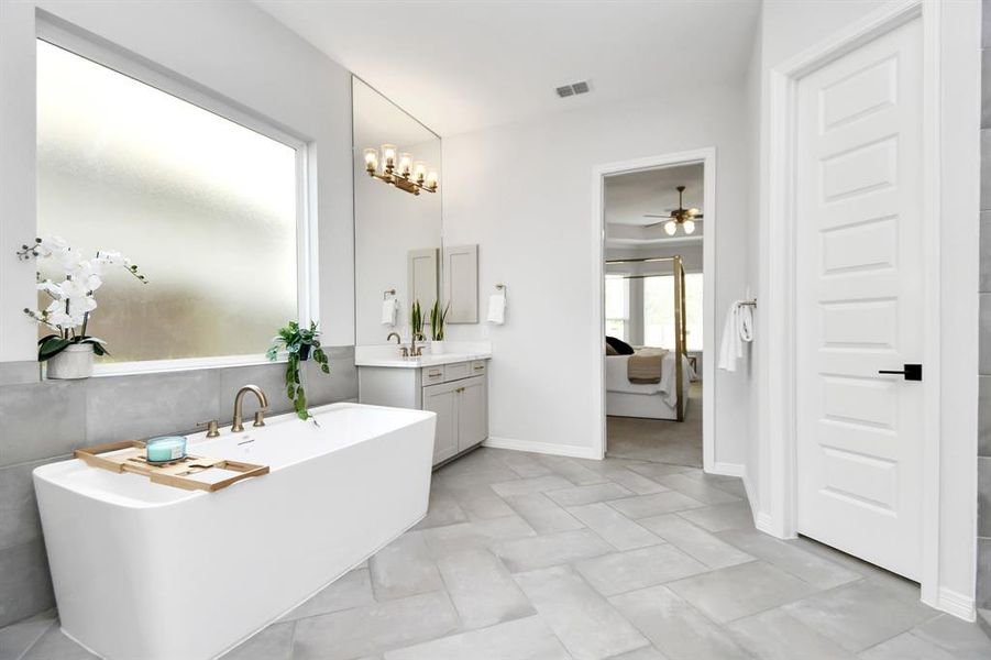 The primary bathroom also has awalk-in shower with tile surround, tilefloors, and glass door.