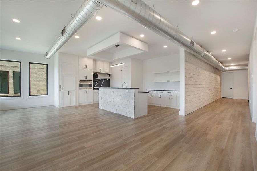 Unfurnished living room with sink and light wood-type flooring