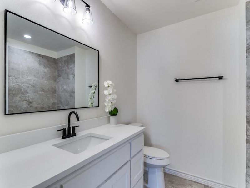 Bathroom featuring vanity, toilet, and tile patterned floors