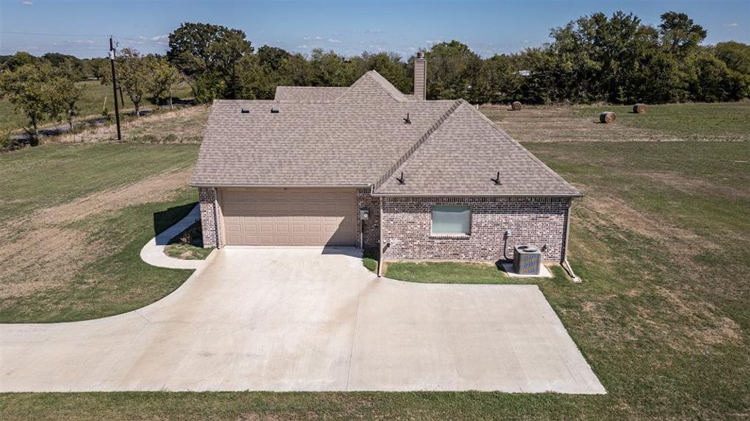 View of front of property featuring a front lawn and a garage