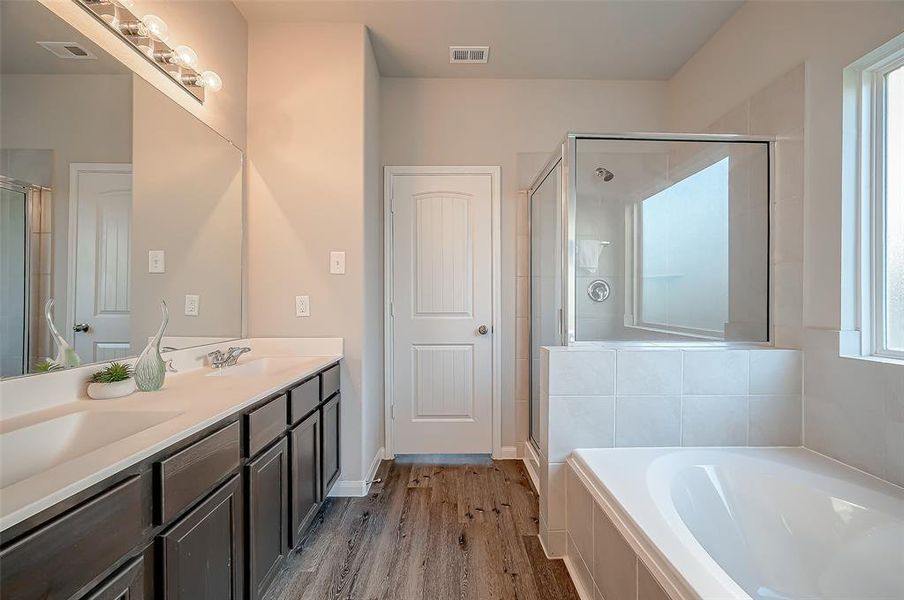 The primary bathroom offers a spa-like retreat, featuring dual sinks for convenience and a soaking tub for ultimate relaxation. It's a blend of luxury and practicality, designed to cater to your comfort and convenience.