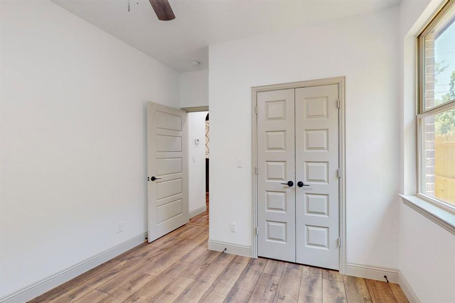 Unfurnished bedroom featuring light hardwood / wood-style floors, a closet, and ceiling fan