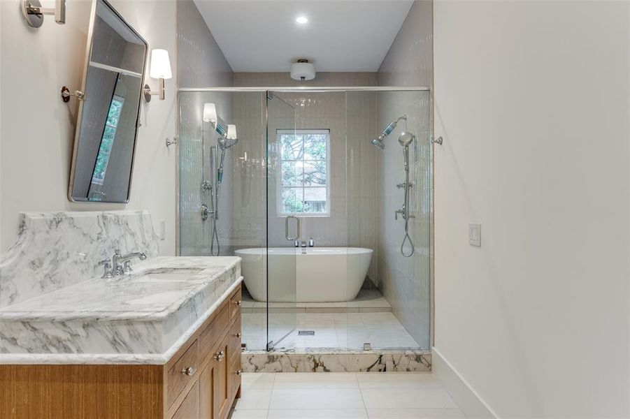 Bathroom featuring tile patterned floors, separate shower and tub, and vanity