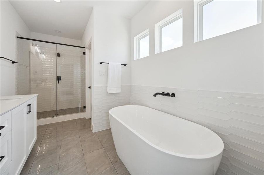 Large walk in shower with matte mosaic gray hexagon floor tiles.