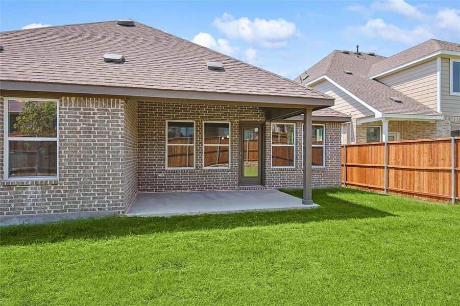 Rear view of house with a patio area and a yard