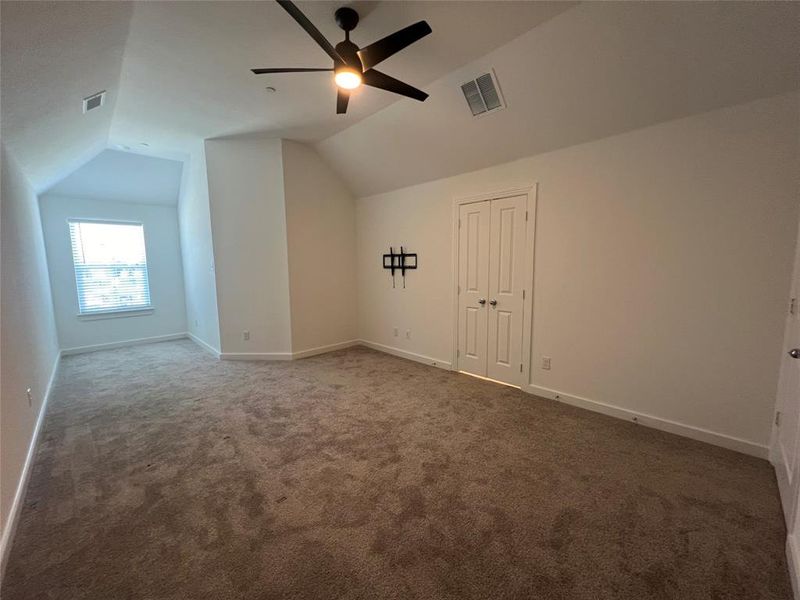 Bonus room with lofted ceiling, ceiling fan, and carpet