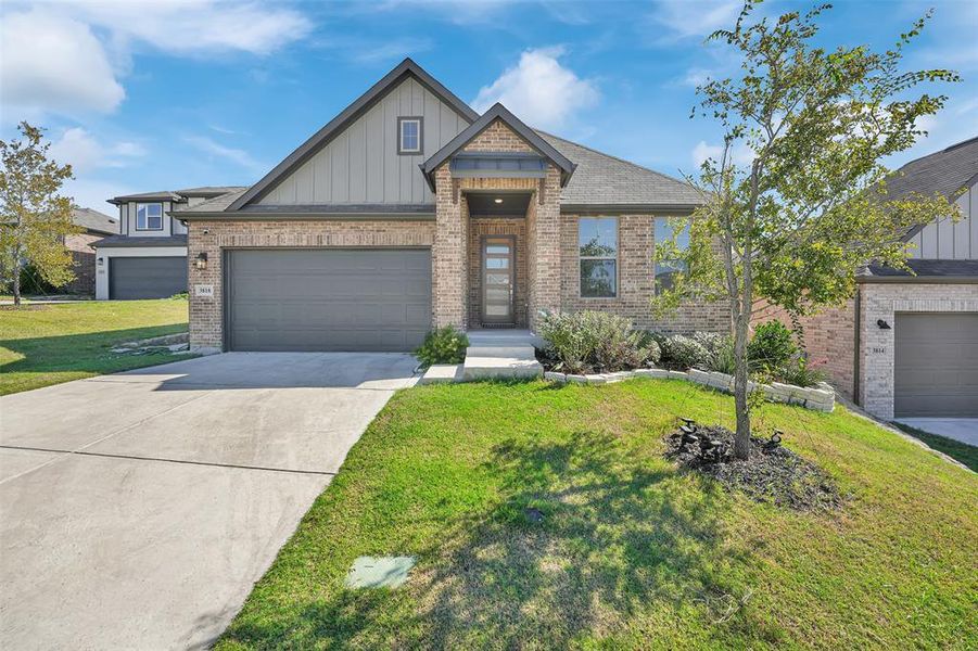 Craftsman inspired home featuring a front lawn and a garage