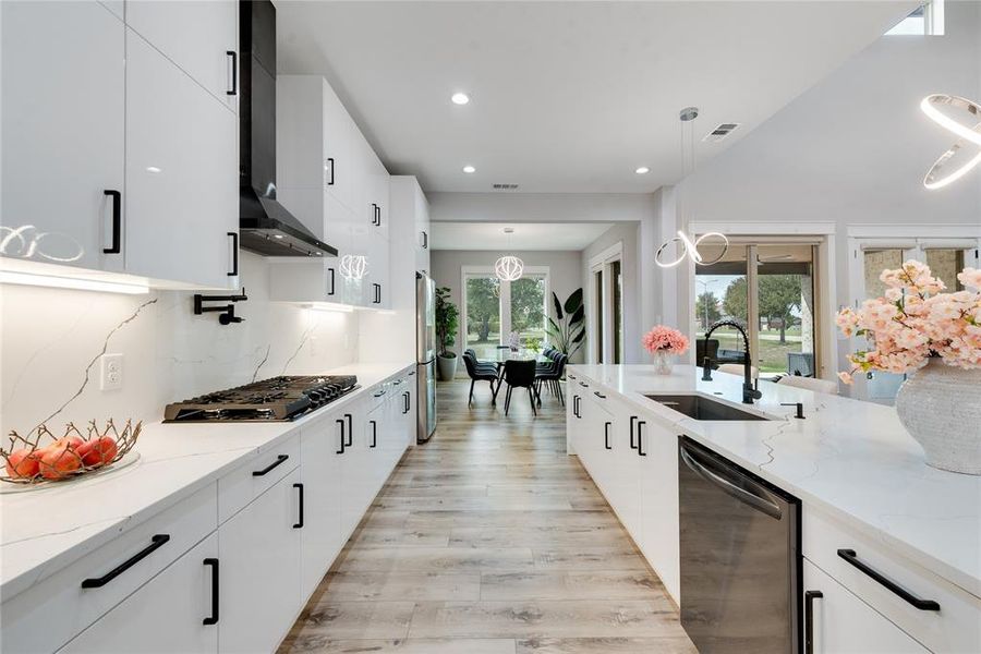 Kitchen with plenty of natural light, stainless steel appliances, and decorative light fixtures