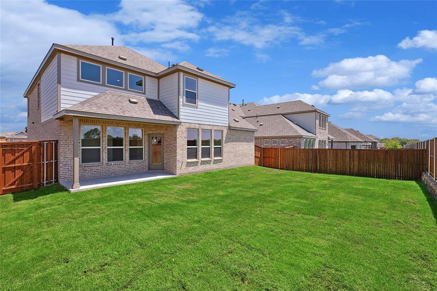 Back of property featuring a yard and a patio