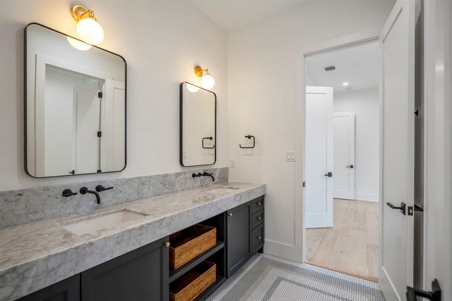 Dual vanities in this beautiful bathroom with a closed door between this area and the water closet/bathtub.