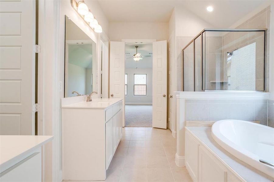 Bathroom featuring independent shower and bath, tile patterned floors, vanity, and ceiling fan