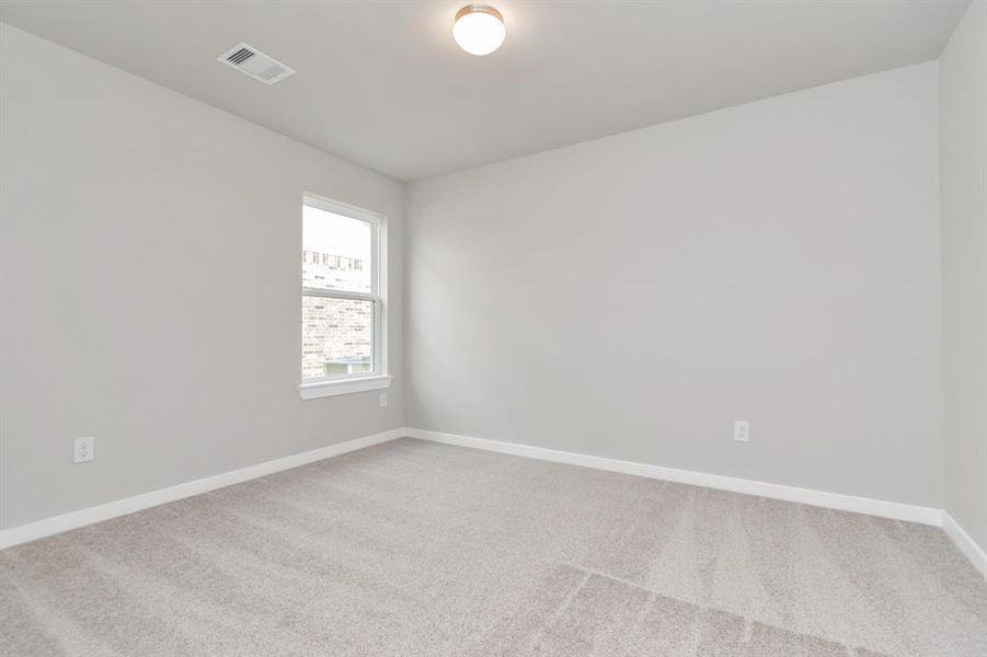 Generously sized secondary bedrooms featuring spacious closets, soft and inviting carpeting underfoot, large windows allowing plenty of natural light. Sample photo of completed home with similar floor plan. As-built interior colors and selections may vary.