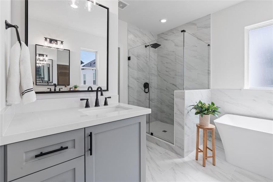 The stunning view of the primary bathroom unveils its opulent amenities, including a spa-like soaking tub, an expansive walk-in shower, and sleek, modern fixtures, promising a luxurious, rejuvenating retreat.