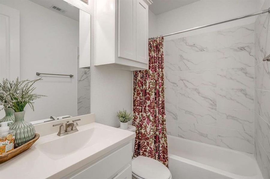 Full bathroom with vanity, toilet, and shower / tub combo with curtain