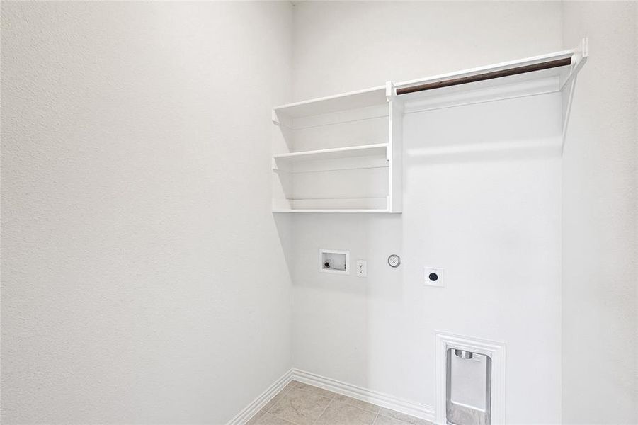 Laundry area with hookup for a washing machine, gas dryer hookup, light tile patterned floors, and hookup for an electric dryer