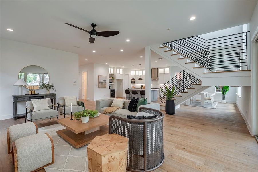 Living room with ceiling fan, sink, and light hardwood / wood-style floors