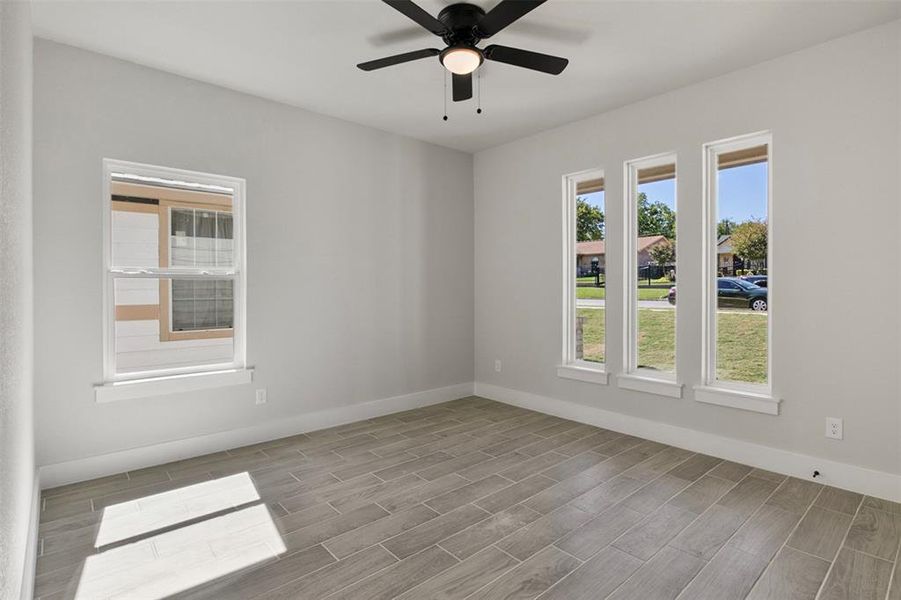 Empty room with ceiling fan and light hardwood / wood-style flooring