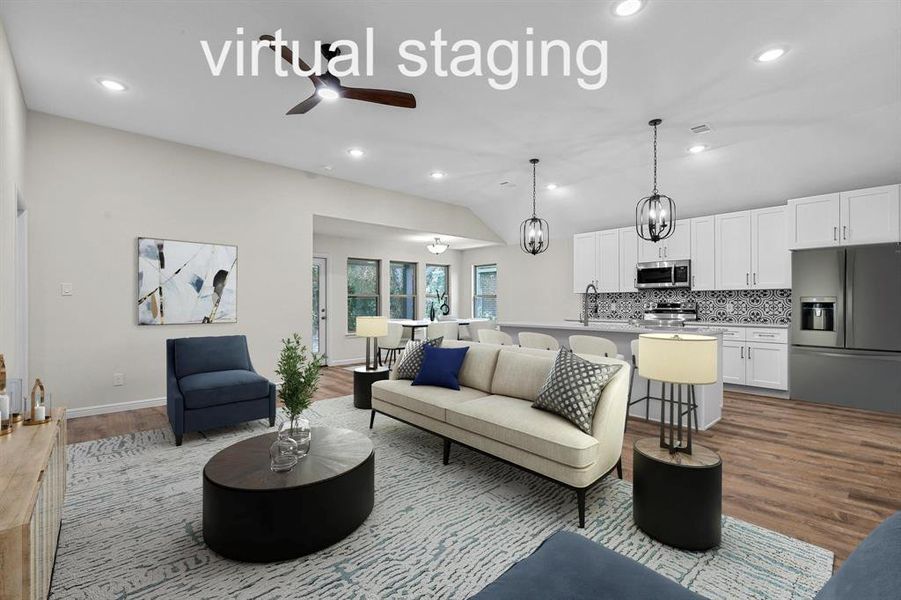 Living room featuring ceiling fan, vaulted ceiling, and light hardwood / wood-style floors