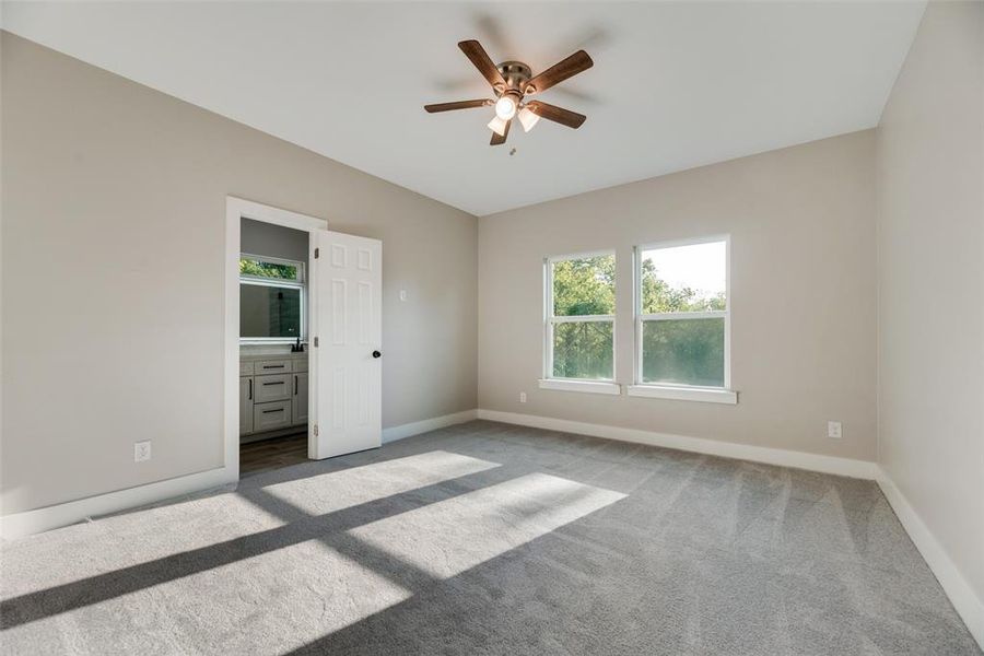 Unfurnished Master bedroom with carpet, ensuite bathroom, and ceiling fan