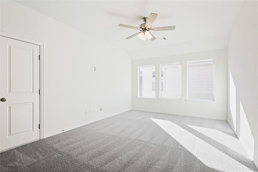 Carpeted spare room featuring ceiling fan