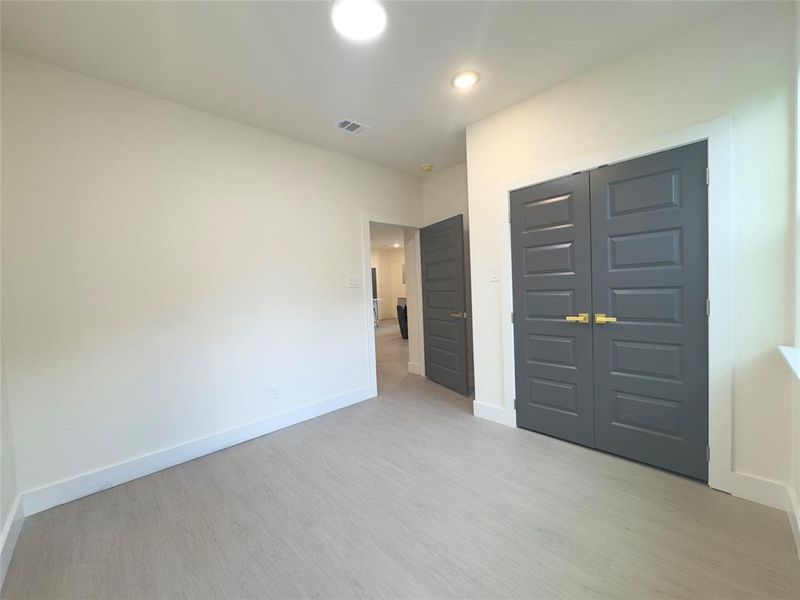 Unfurnished bedroom with light hardwood / wood-style flooring and a closet