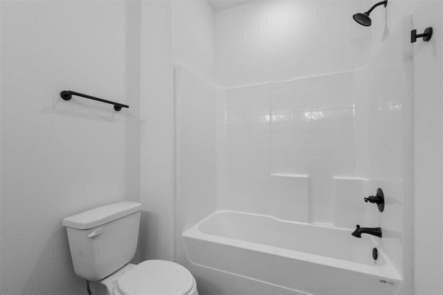 Bathroom featuring bathing tub / shower combination and toilet