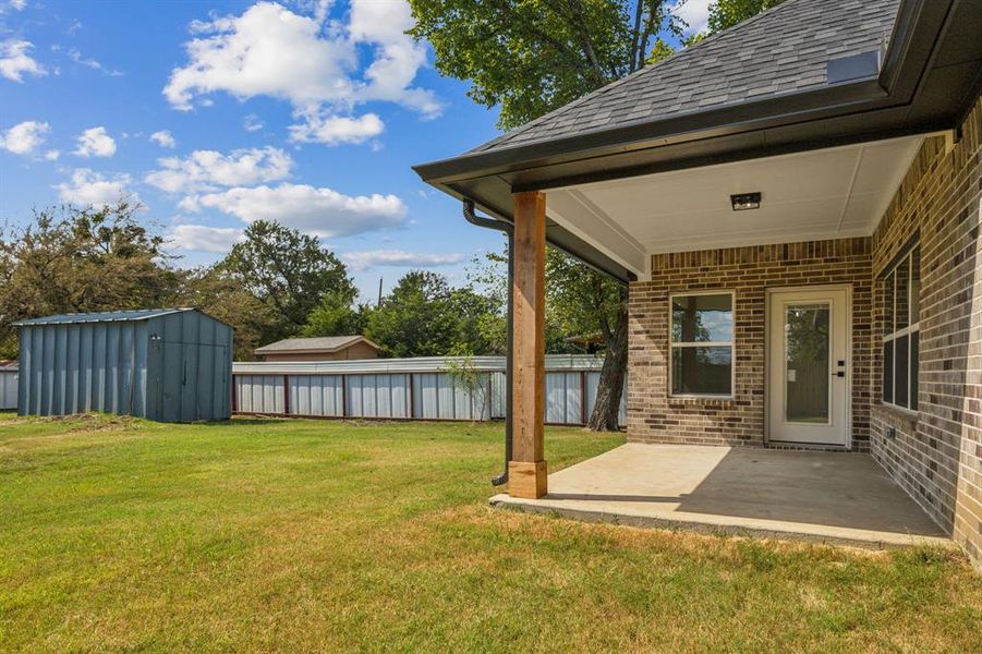 View of yard featuring a shed and a patio area