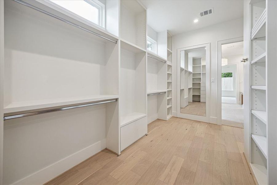 The primary suite's L-shaped custom closet is pretty incredible! This closet gets extra points for natural lighting, a full length mirror and laundry room access!