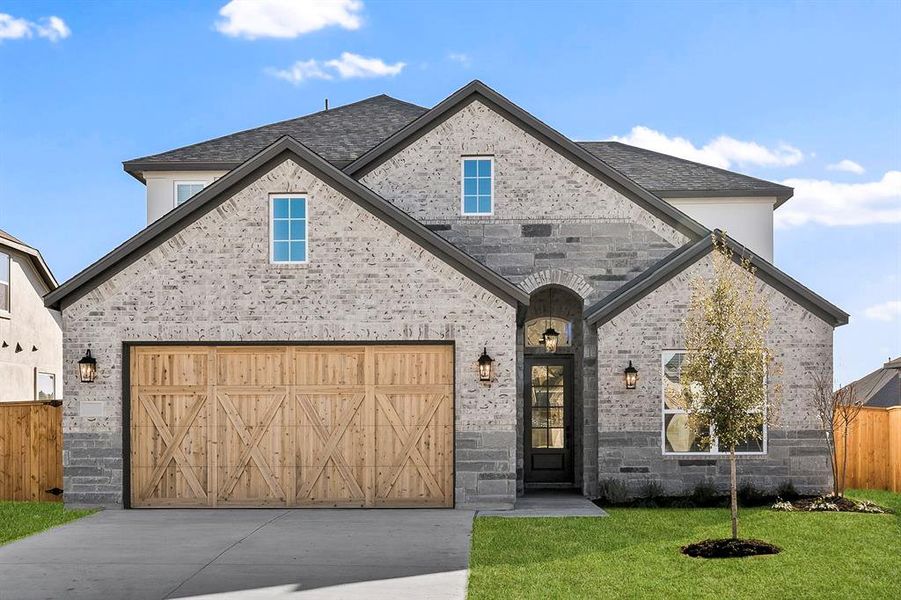 The Welch plan at The Colony is a beautiful two-story home with a long driveway, gorgeous cedar garage door, and lush front yard landscaping.