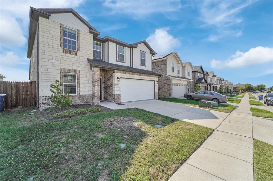 View of front of property featuring a front yard and a garage