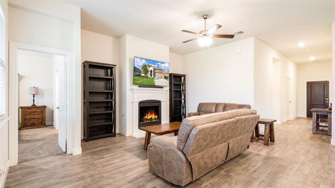 Living room with ceiling fan and light colored carpet