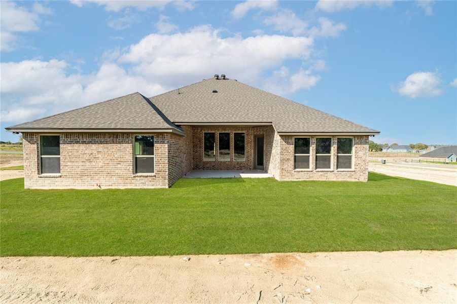 Back of house with a lawn