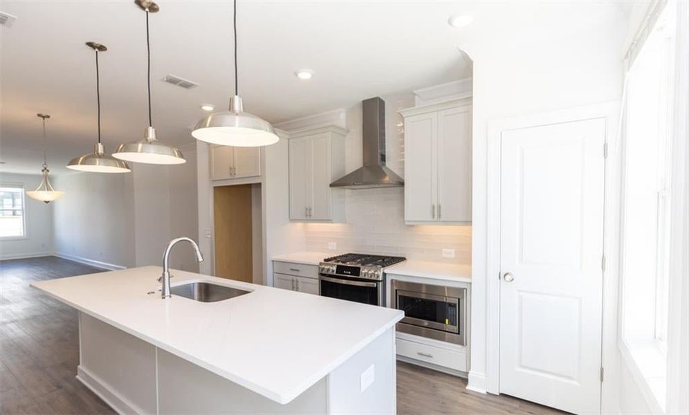 Great pendant lighting found over large kitchen island. Photo not of actual home but of previously built TPG property.