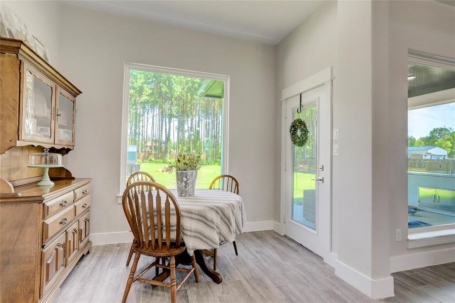 START YOUR MORNINGS IN THIS CHARMING BREAKFAST NOOK OFFERING SERENE VIEWS OF THE SURROUNDING PINE FOREST THROUGH LARGE WINDOWS, CREATING A PEACEFUL SPACE FOR INTIMATE MEALS AND QUIET CONTEMPLATION.