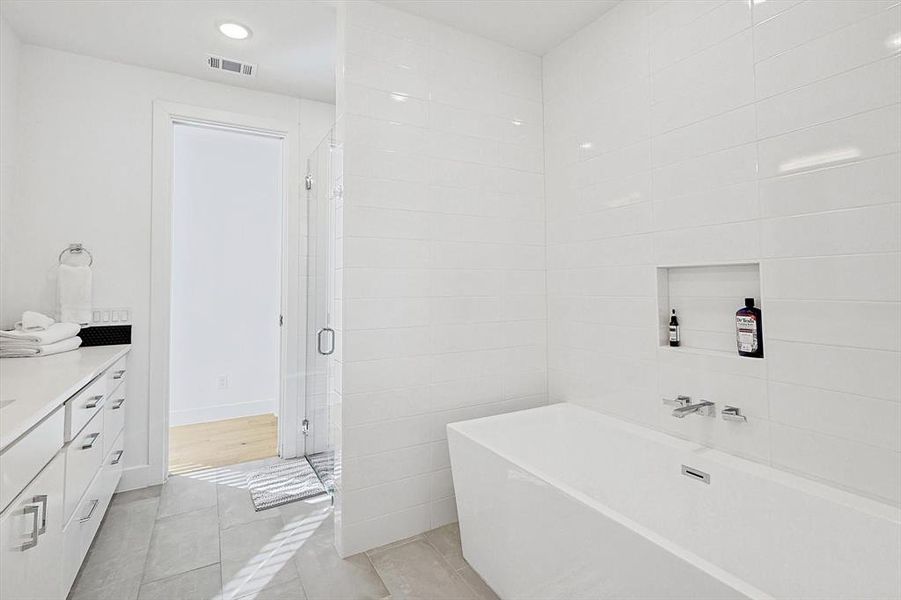 Bathroom with vanity, tile walls, tile patterned floors, and separate shower and tub