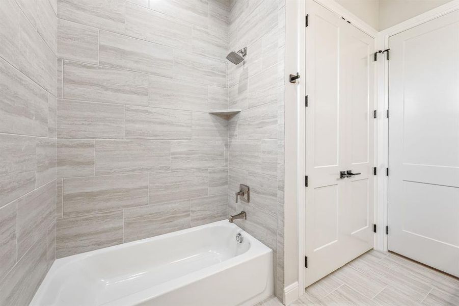 Bathroom with tile patterned floors and tiled shower / bath