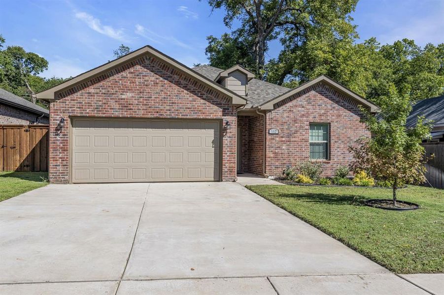 View of front of house with a garage and a front lawn