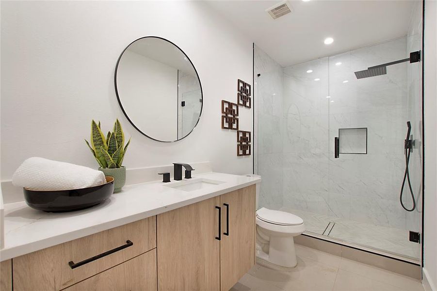 Bathroom featuring vanity, toilet, tile patterned floors, and walk in shower