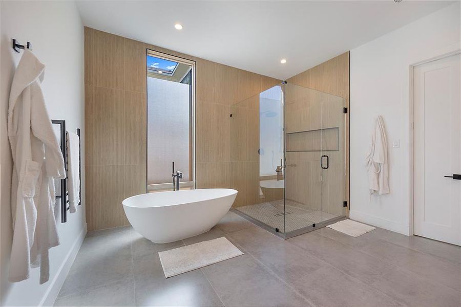 Bathroom featuring concrete floors and shower with separate bathtub