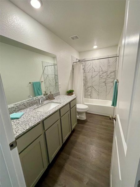 Extra large vanity in this guest bath that services bedroom 2 and 3. Quality granite counters.