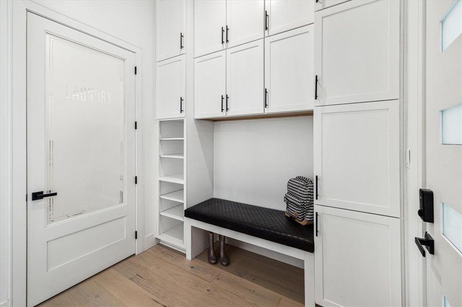 View of the door leading to the laundry room, complemented by floor-to-ceiling cabinets in the mudroom